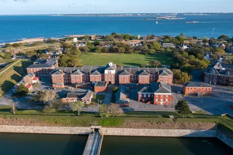 A waterfront urban neighborhood with brick residential buildings and green spaces.