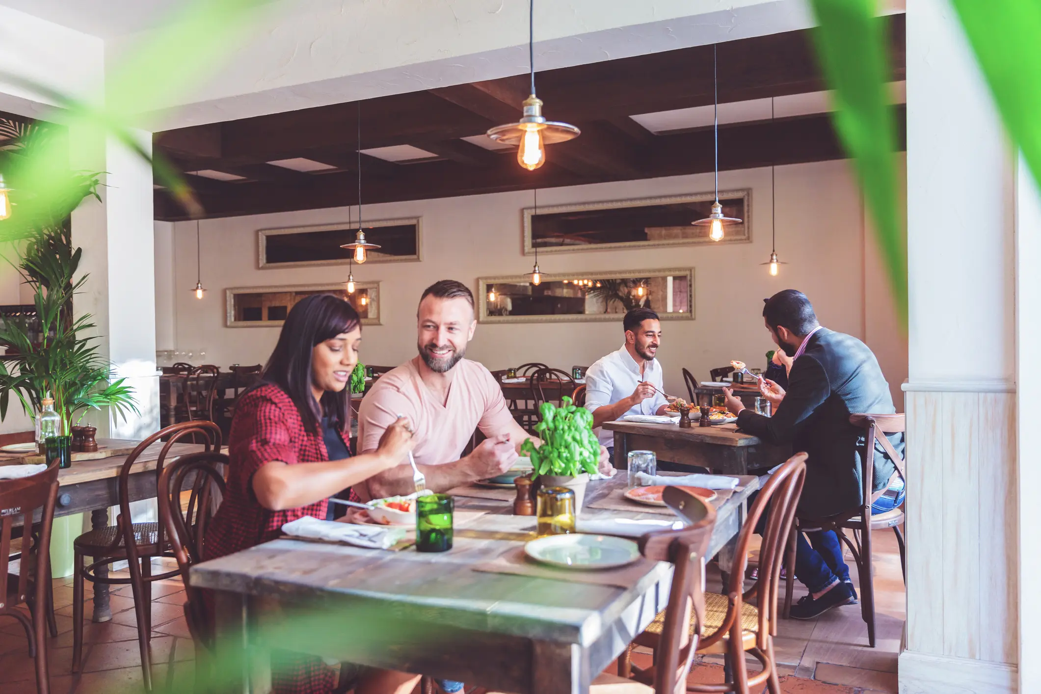 People enjoying meals and conversations in a cozy restaurant.