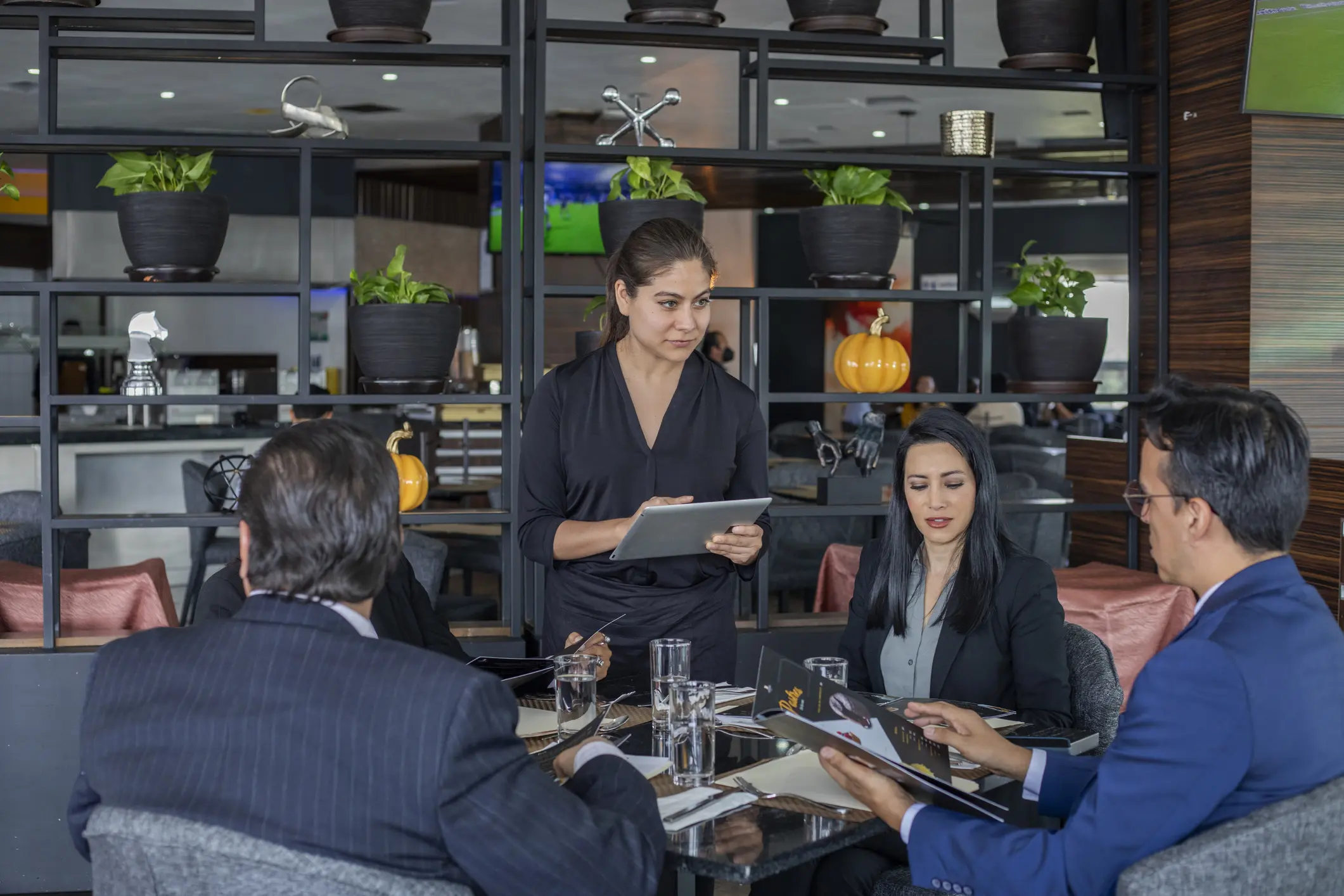 A business meeting with four professionals discussing around a table.
