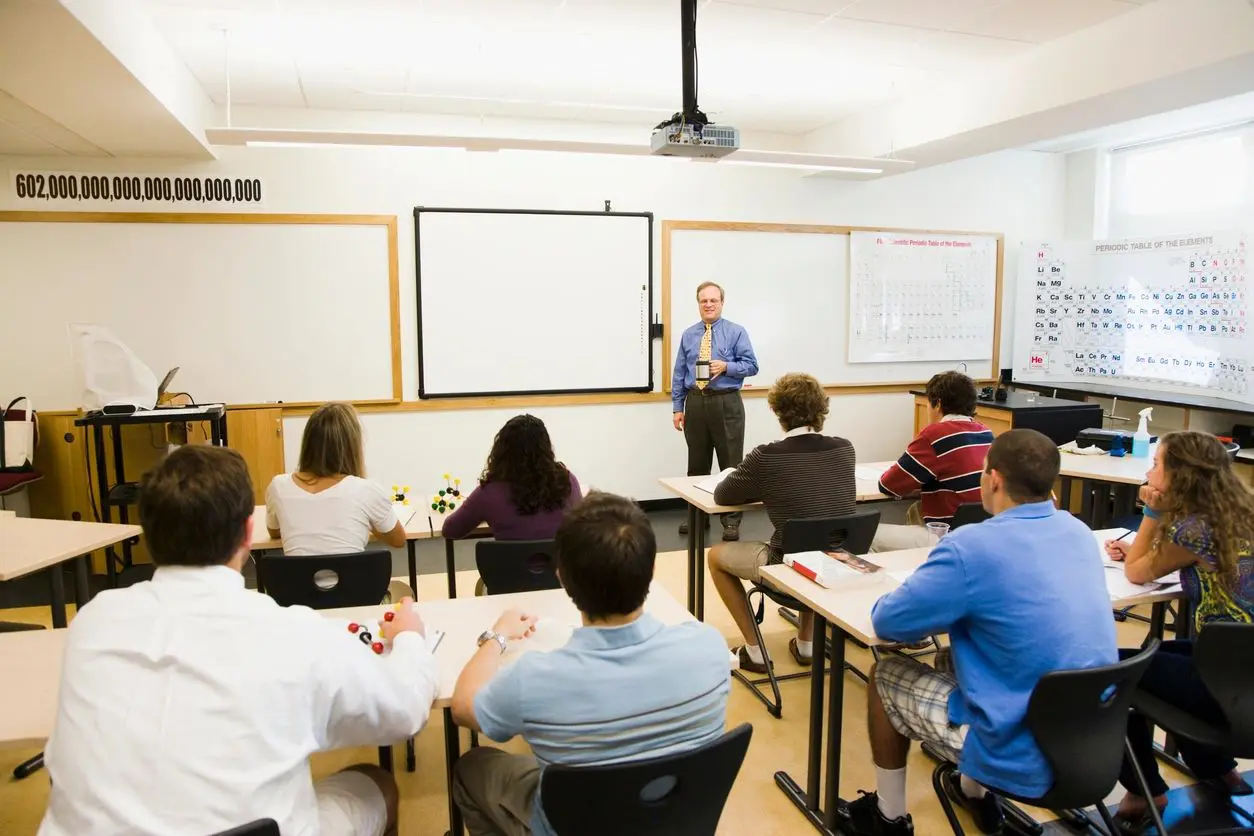 Teacher instructs students in a classroom setting.