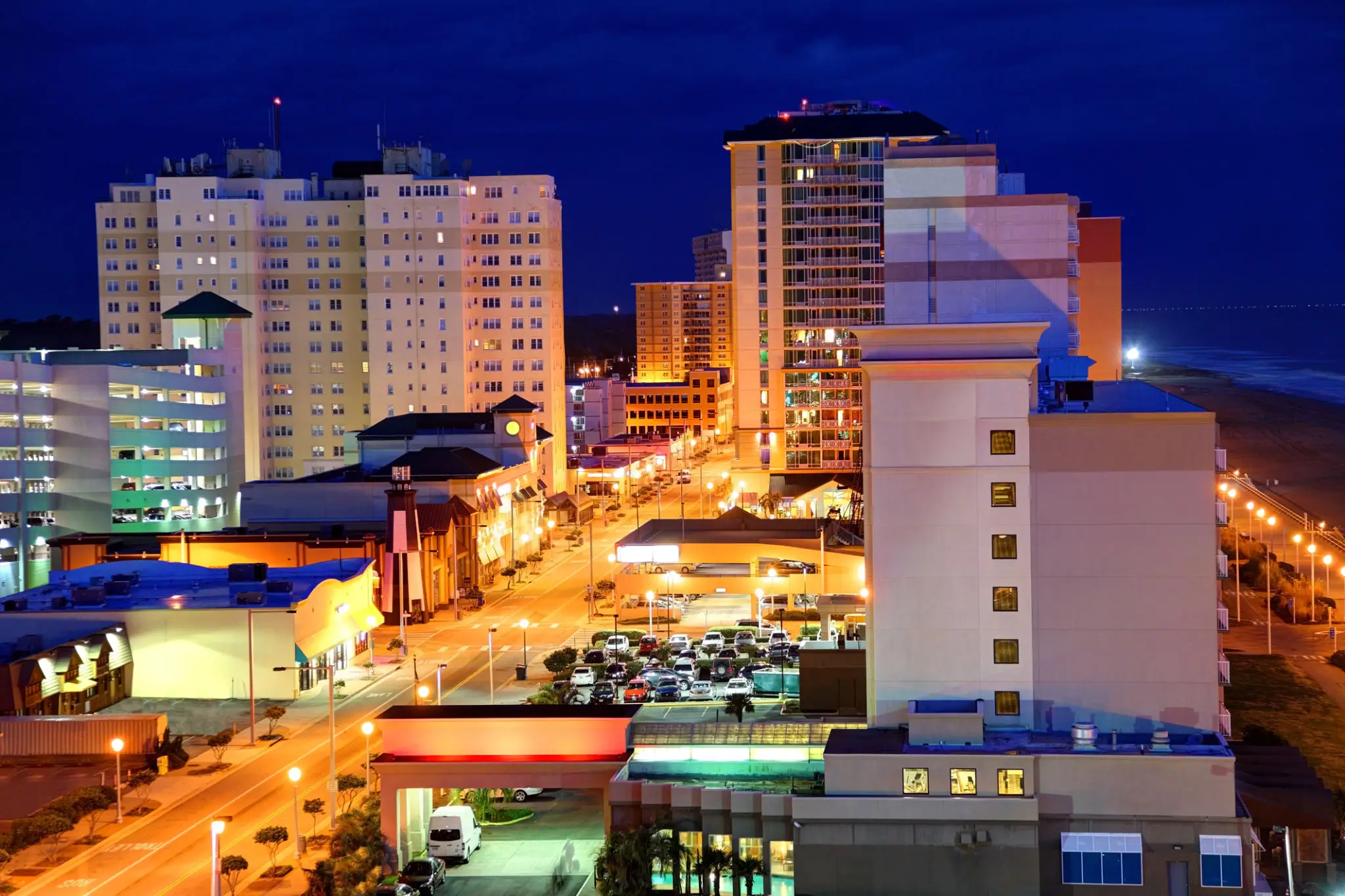 Cityscape at night with illuminated streets and buildings.