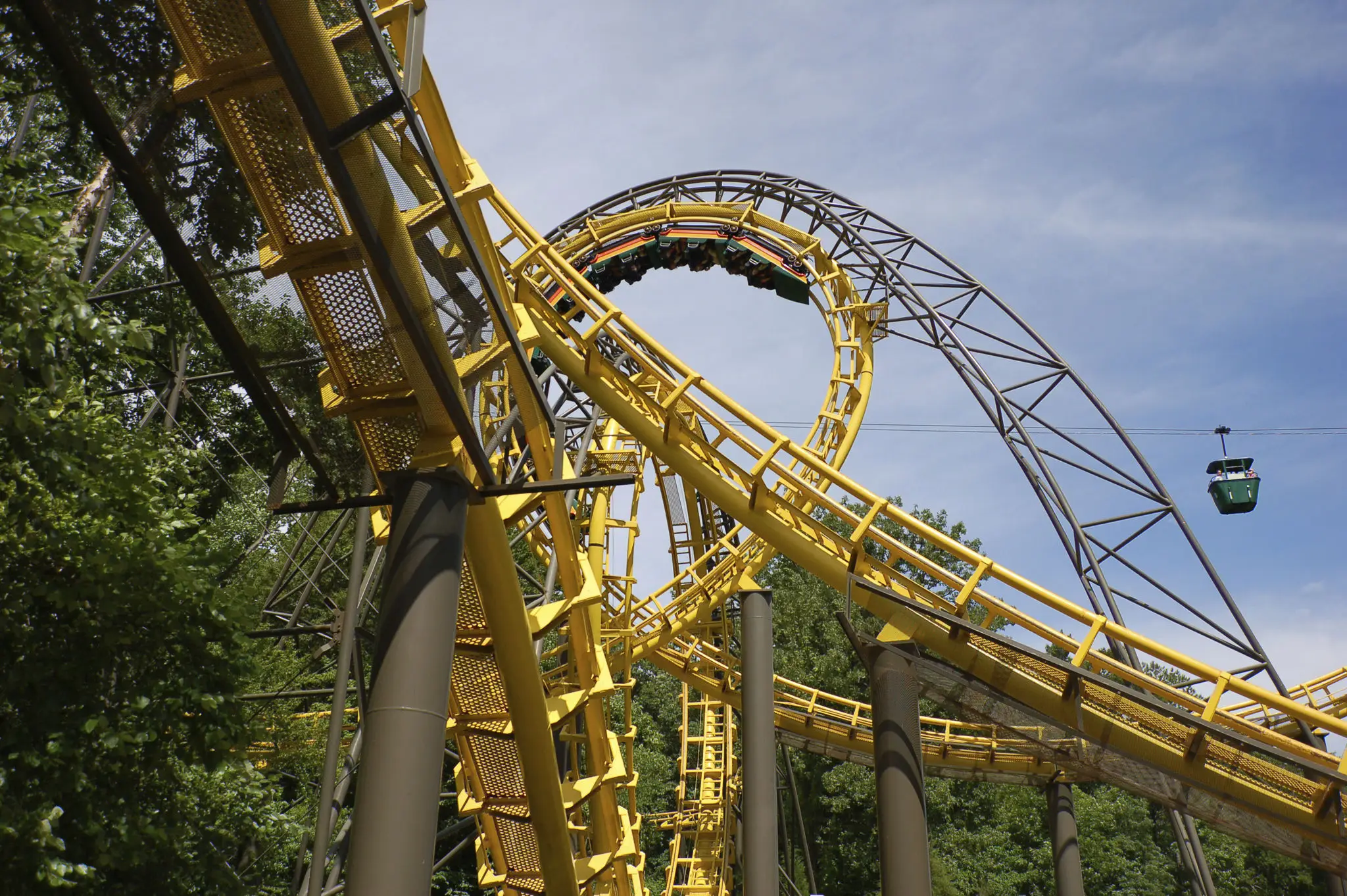 Yellow roller coaster with loops and twists.